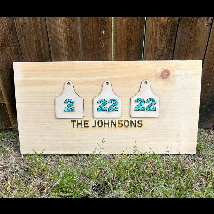 a wooden sign with three tags on it that says, the johnsons 22 and 23