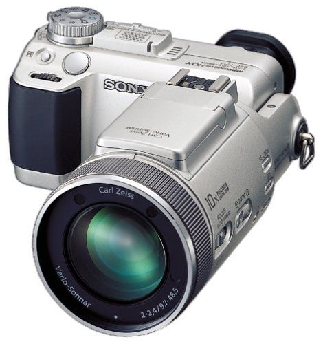 a silver digital camera sitting on top of a white surface