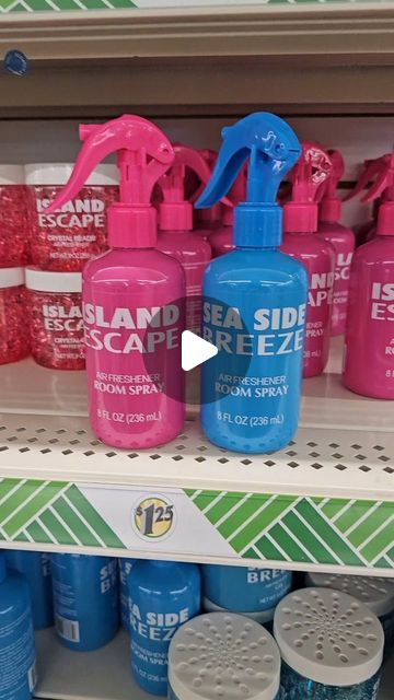 several spray bottles on a shelf in a store with pink and blue ones next to each other