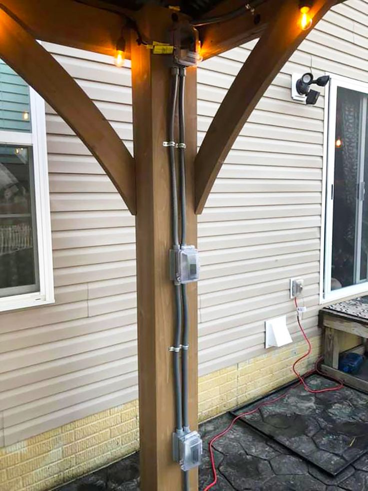 an outdoor patio with lights on the side of it and a wooden pergolan