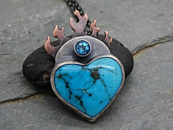 Flaming Heart Pendant Turquoise Heart Pendant, Flaming Sacred Heart Pendant Mixed Metal, Turquoise Mountain Heart Necklace, Gift For Her// Big flaming heart pendant with a stunning Turquoise gemstone.// Awesome as a gift for men and women alike, and also to keep for yourself.// Turquoise is a December birthstone. Also a great gift for your 6th and 11th anniversary.> pendant overall hanging length is 37mm (1.45 inches) > Turquoise mountain Turquoise and blue Topaz gemstones> hand made fr Spiritual Jewelry With Heart Pendant And Natural Stones, Blue Bohemian Heart Pendant Jewelry, Bohemian Blue Heart Pendant Jewelry, Unique Heart Pendant Jewelry For Healing, Turquoise Heart Pendant Jewelry With Natural Stones, Turquoise Heart Pendant Necklace With Gemstone, Turquoise Heart-shaped Necklaces For Gifts, Turquoise Heart-shaped Necklace For Gift, Turquoise Heart Necklaces For Gift