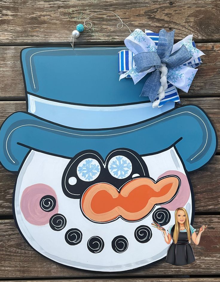 a paper cut out of a snowman with a blue hat and mustache on it