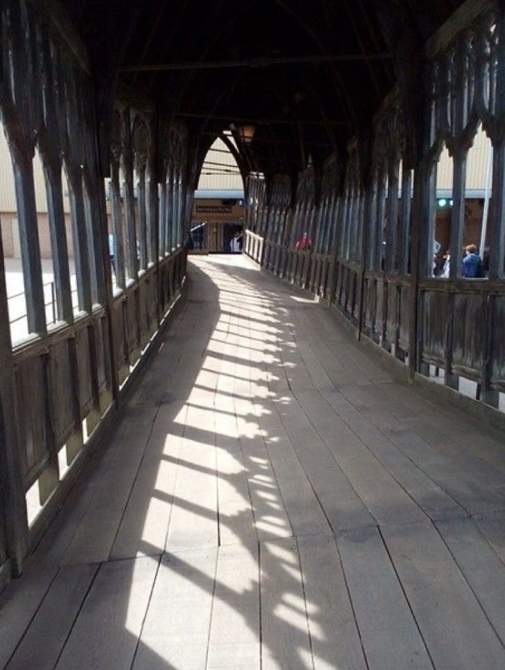 a wooden walkway with metal posts and railings