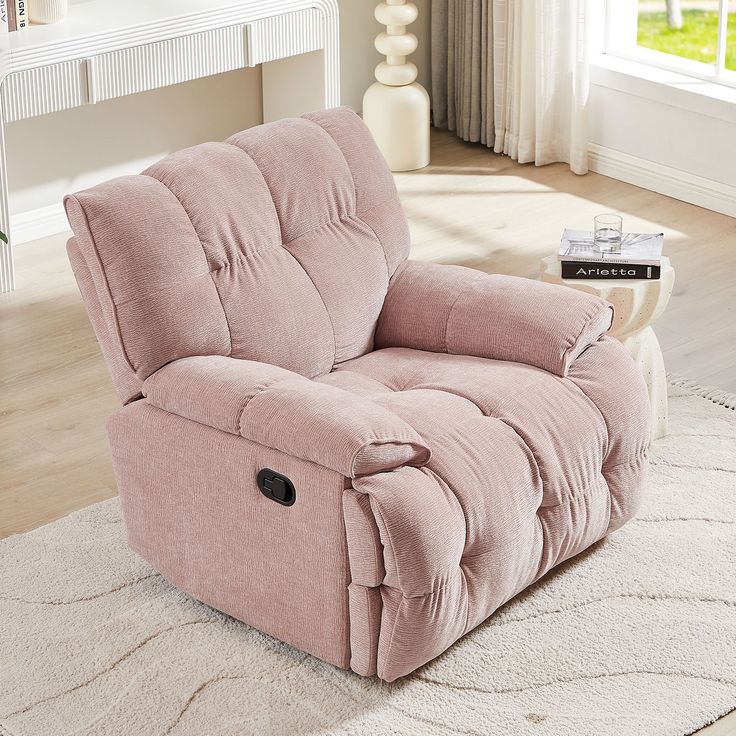 a pink recliner sitting on top of a white rug