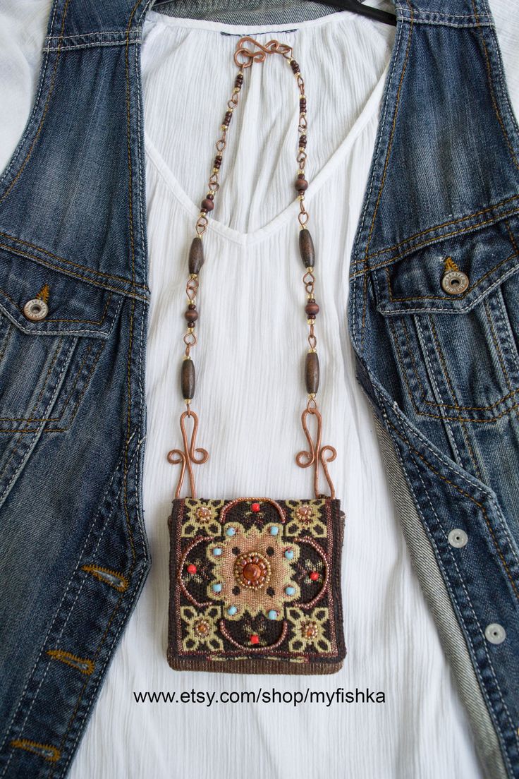 a woman's white shirt and jean jacket with a purse hanging from the back