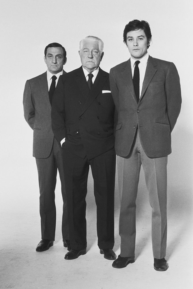 three men in suits standing next to each other