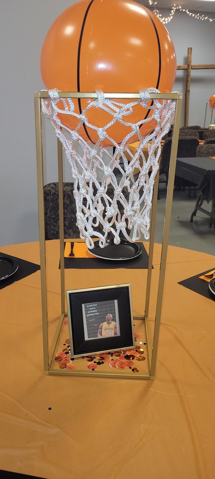 an orange basketball is on display in front of a gold frame with a framed photo