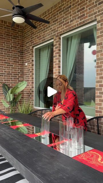 a woman is sitting at a table outside