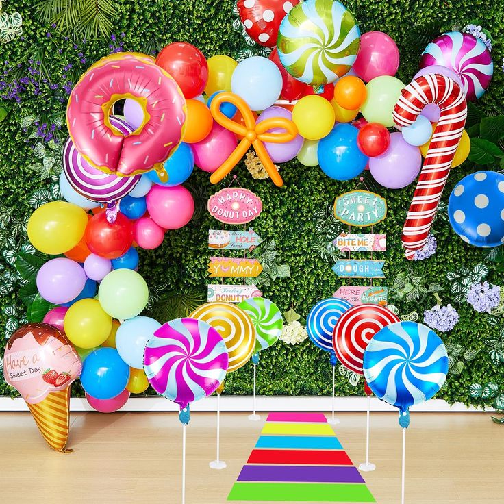 an assortment of candy and lollipops are displayed in front of a backdrop