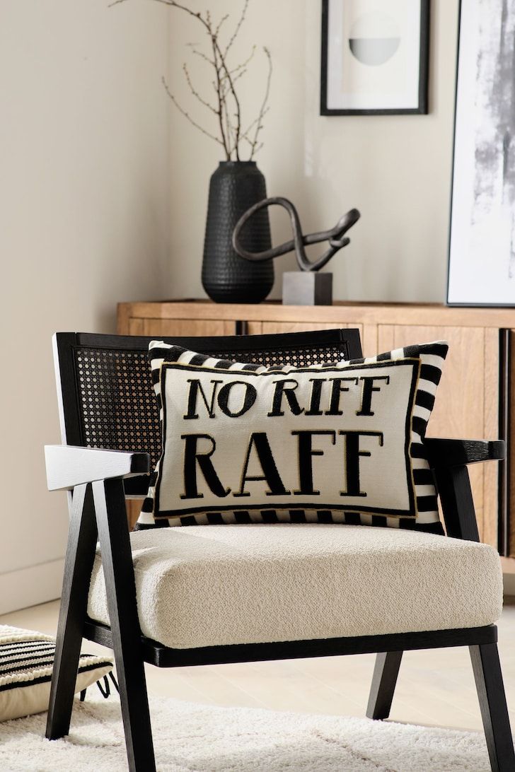 a black and white pillow sitting on top of a chair