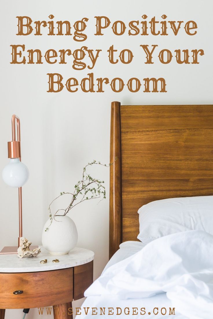 a bedroom with a bed, nightstand and bedside table in front of the wall that says bring positive energy to your bedroom