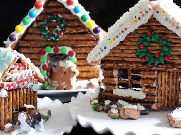 two gingerbread houses decorated with icing and candy