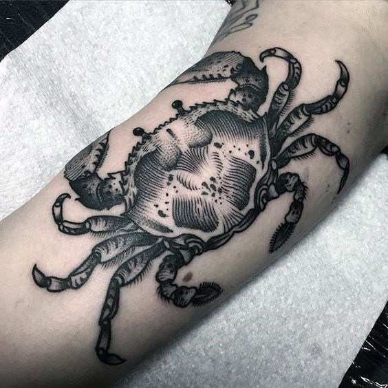 a black and white crab tattoo on the arm