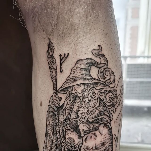 a man's leg with a wizard tattoo on it