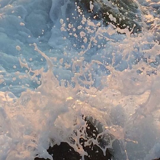 the water is splashing up against the rocks