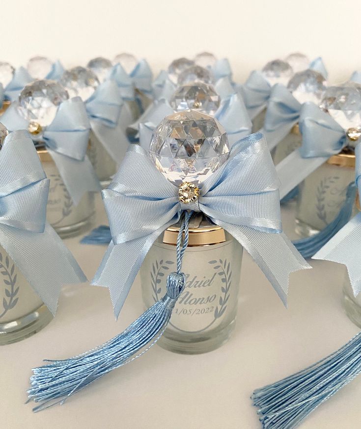 small glass jars with blue ribbons and bows