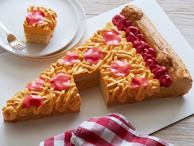 a piece of cake with red and yellow icing on it next to a fork