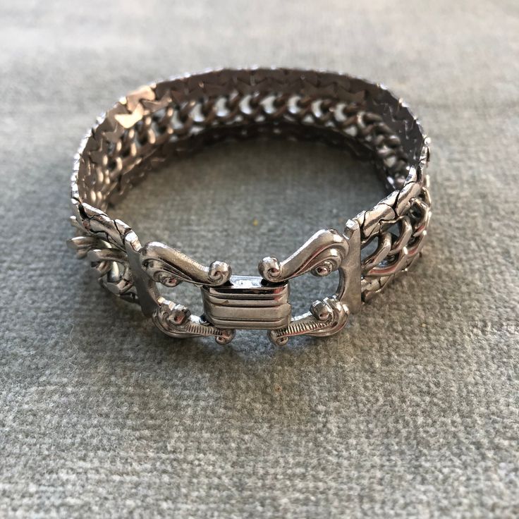 "This bracelet has some weight to it. The curb chain at the center is flanked by snake chains which are soldered to it so the piece moves as a sinuous whole. The clasp belies the more modernist look of the chain, with it's lyre shaped finials holding the fold over closure. The piece measure 7 3/4\" long by 3/4\" wide.  I'm happy to ship internationally but costs have risen so dramatically I can no longer ship worldwide for $12. If you are outside of the US and want to make a purchase. Let me kno Formal Cuban Link Metal Bracelets, Formal Cuban Link Metal Bracelet, Modern Metal Bracelets With Snake Chain, Elegant Adjustable Cuban Link Bracelet With Box Chain, Elegant Metal Cuban Link Bracelet With Curb Chain, Metal Curb Chain Jewelry For Formal Occasions, Adjustable Metal Jewelry With Curb Chain, Formal Chain Link Bracelet With Hook And Links, Metal Box Chain Link Bracelet