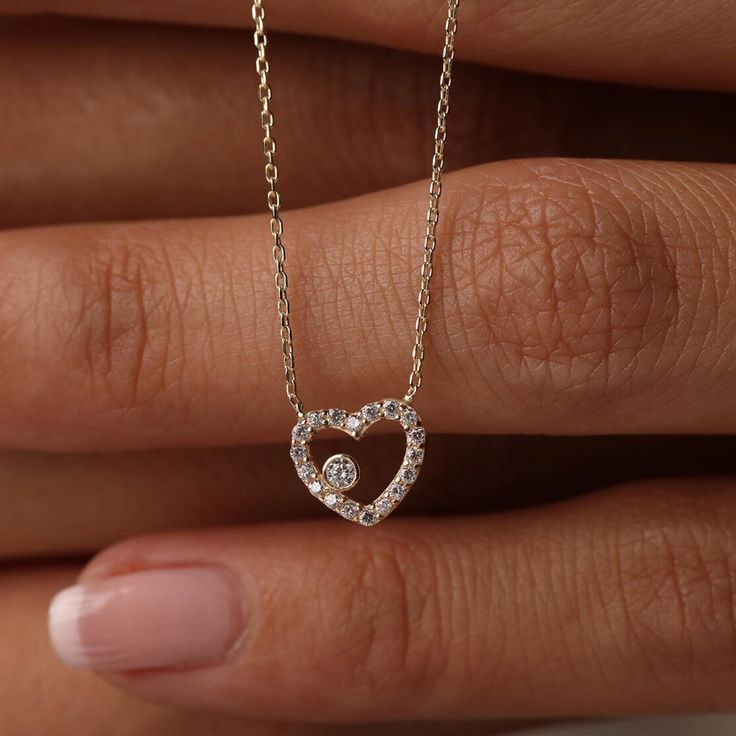 This 14K Gold Open Heart Necklace with CZ Pave is a beautiful and versatile piece, perfect for any occasion. Its minimalist design and sparkling cubic zirconia accents make it suitable for both daily wear and special events. Ideal as a birthday gift or a present for a bride, this necklace symbolizes love and affection. Pair it with matching jewelry for a coordinated look. Its quality craftsmanship and timeless design ensure it will be cherished for years to come. Product Features: * Made to Order: Crafted specifically to your preferences. * Gold KT: 14K Solid Gold (not filled, not gold vermeil, not plated) * Gold Color Options: Choose from Yellow, Rose, or White Gold, tailoring the necklace to your preferred style. * Gemstone: Adorned with a dazzling Cubic Zirconia, adding a touch of brill Heart Cut Heart Charm Necklace For Wedding, Heart Cut Necklace With Heart Charm For Wedding, Wedding Necklace With Heart Charm And Cubic Zirconia, Diamond Heart Necklace For Wedding On Valentine's Day, Wedding Cubic Zirconia Necklace With Heart Charm, Wedding Heart Necklace With Diamond Accents For Valentine's Day, Valentine's Day Wedding Heart Necklace With Diamond Accents, Valentine's Day Wedding Diamond Heart Necklace, Diamond Heart Charm Necklace For Wedding