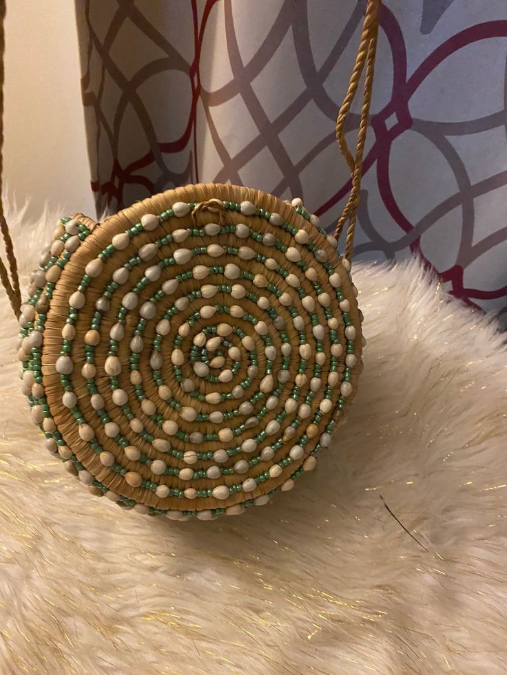 a handmade purse with beads on it sitting on top of a white fur rug