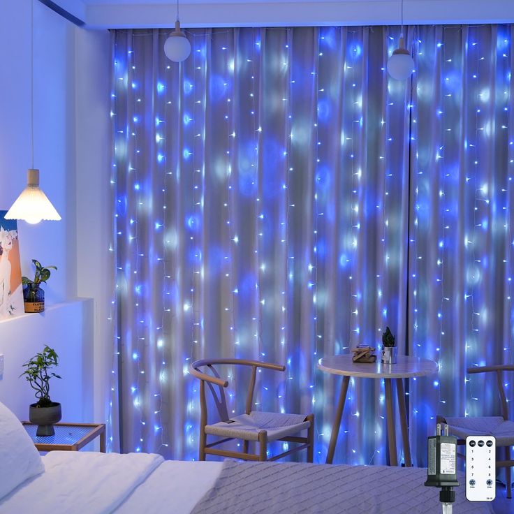 a bed room with a neatly made bed and blue lights on the wall behind it