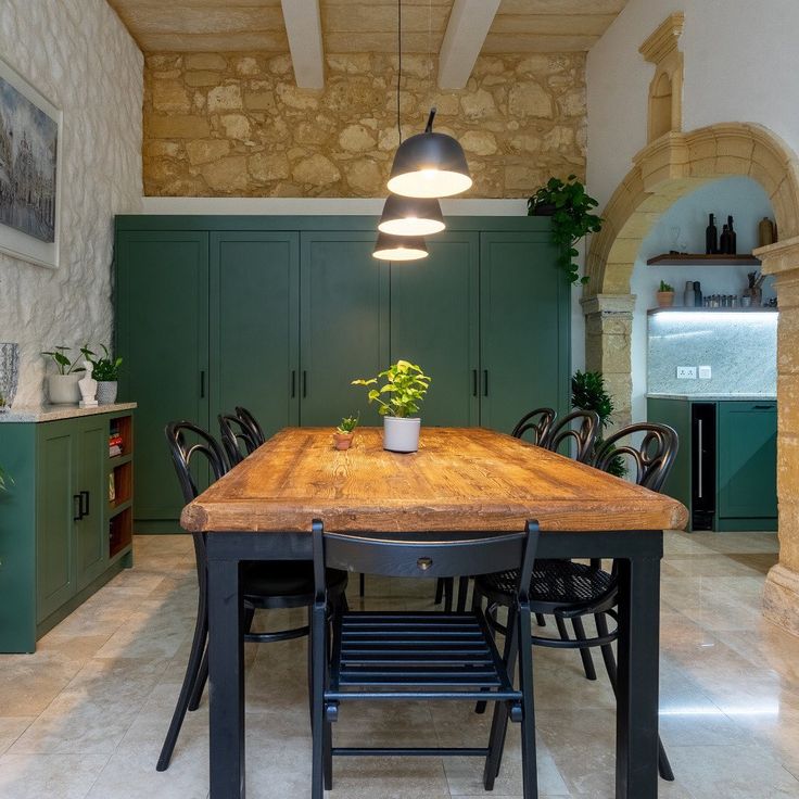 a dining room table with chairs and a potted plant sitting on top of it