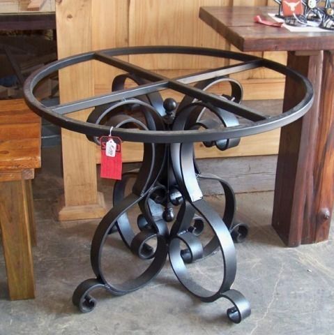 a metal table with two chairs and a wooden bench in the background