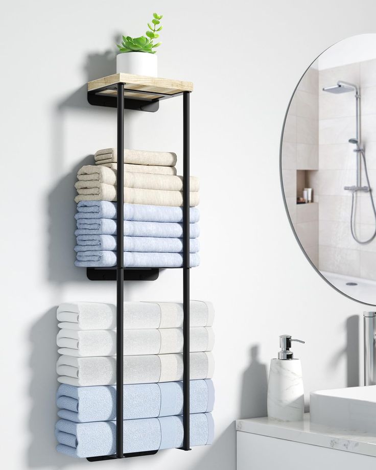 towels are stacked on a shelf next to a mirror