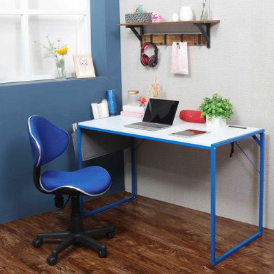 a computer desk with a laptop on top of it in front of a blue wall