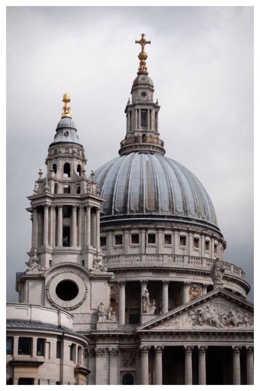 the dome of an old building with two crosses on it's top and another church in the background