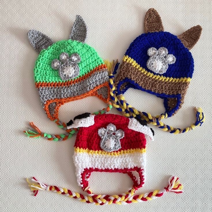 three crocheted hats with ears and tails