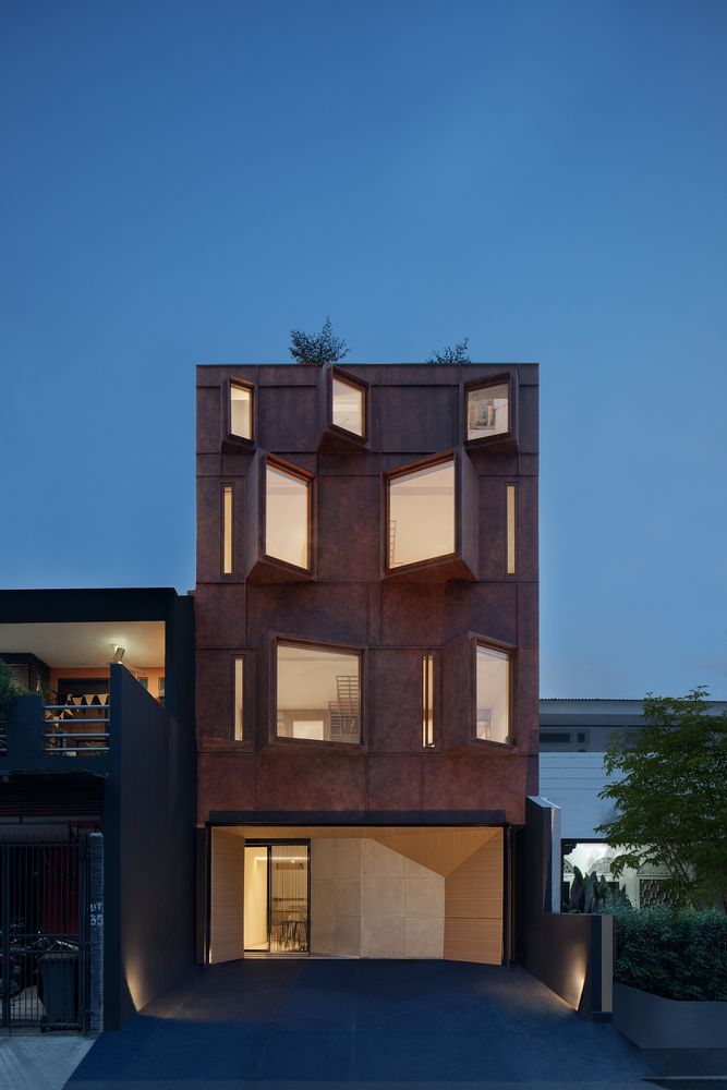 an apartment building with multiple levels and windows on the top floor is lit up at night