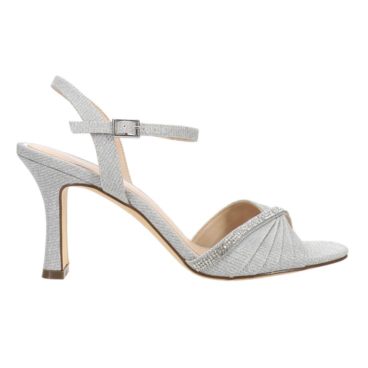 A stunning evening sandal that delivers a touch of modern elegance to your look. Chic pleats of  lustrous satins and metallics are accented with a jewel-encrusted, asymmetrical crystal band, giving a slender and graceful appearance to the foot. Set on a high, but not too high, elegantly shaped heel, and secured with a chic ankle-strap, Agnes by Nina is a sandal that will be a chic addition to your evening footwear wardrobe. $83.95 Glamorous Sparkling Sandals For Gala, Glamorous Glitter Sandals For Formal Occasions, Glamorous Sparkling Formal Sandals, Bedazzled Ankle Strap Heels For Evening, Embellished Fitted Sandals For Prom, Elegant Glitter Sandals For Wedding, Evening Event Sandals With Rhinestones, Formal Bedazzled Ankle Strap Sandals, Glamorous Sparkling Sandals For Events