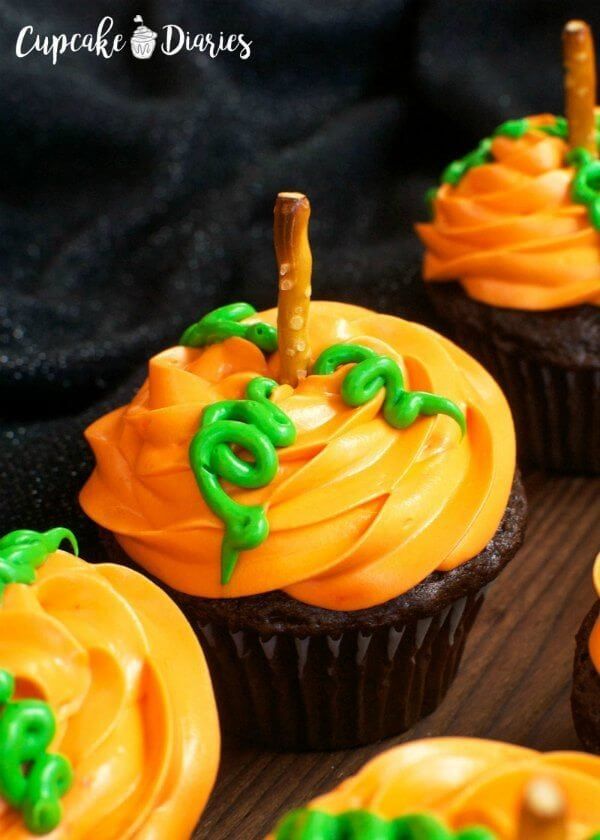 cupcakes decorated with orange icing and green decorations