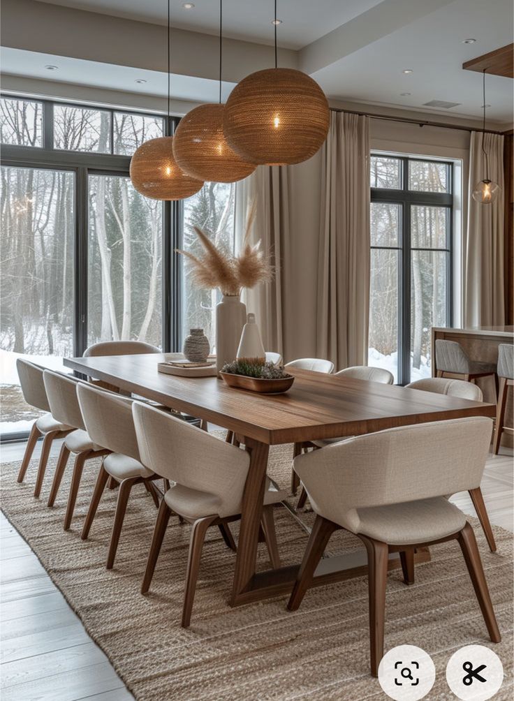 the dining room table is surrounded by beige chairs and round lights hanging from the ceiling