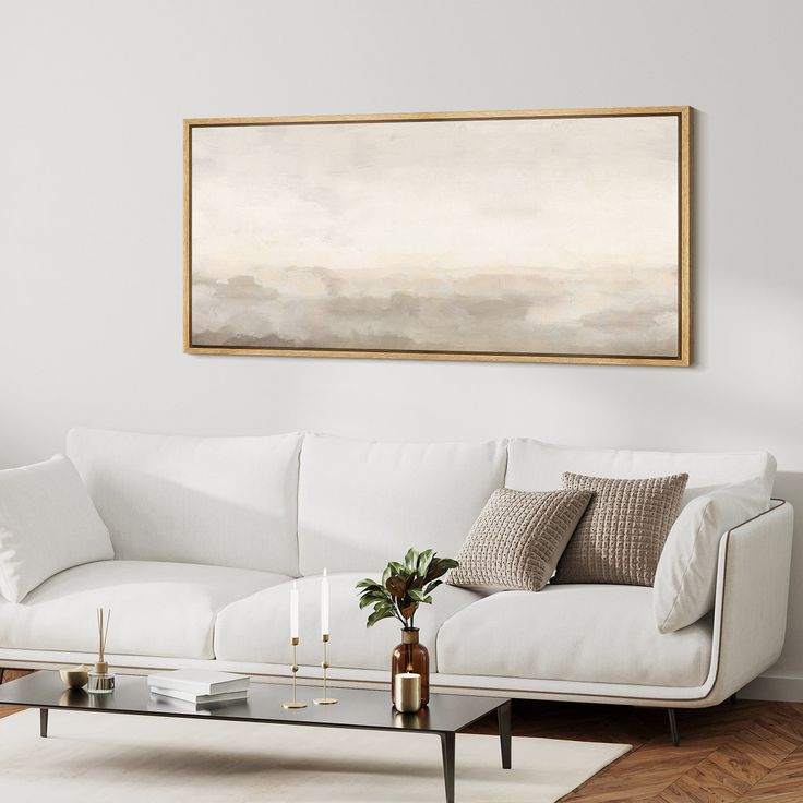 a living room with a couch, coffee table and painting on the wall above it