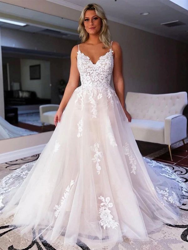 a woman in a white wedding dress standing on a carpeted area with a couch