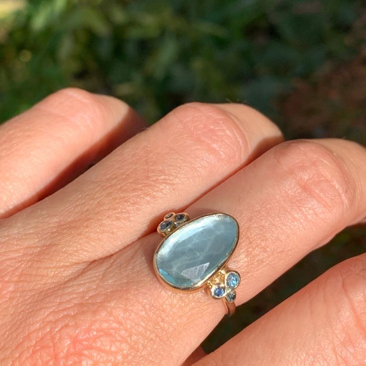 A baby blue Aquamarine is Set in 14k yellow gold with a pair of deep blue and teal sapphires and vibrant blue zircons. Emily's handmade seagrass band finishes this stunning piece. Approx stone size: 15 mm x 9mm Approx stone weight: 4.1cts Mohs Hardness: 7.5-8 This one of a kind piece is handmade to order in Emily's Hudson Valley studio. If you have questions about sizing, shipping or need help deciding please reach out to us! Alternative Engagement Ring, Aquamarine Ring, Local Jewelry, Alternative Engagement Rings, Aquamarine Stone, Aquamarine Rings, Blue Zircon, Aquamarine Blue, Vibrant Blue