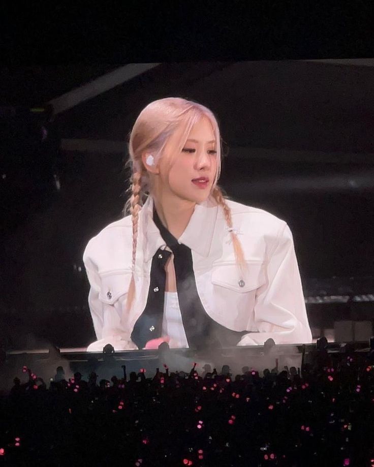 a woman with braids sitting in front of a microphone