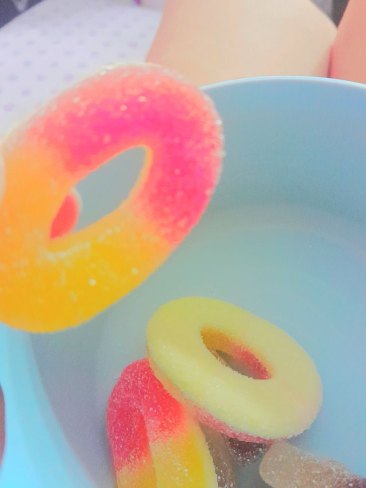 two donuts in a blue bowl with pink and yellow sprinkles