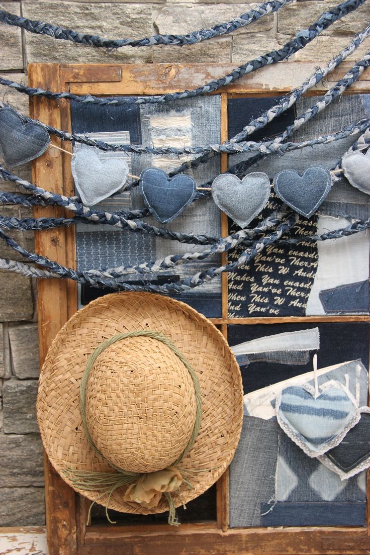 a straw hat sitting on top of a window sill next to blue and white fabric