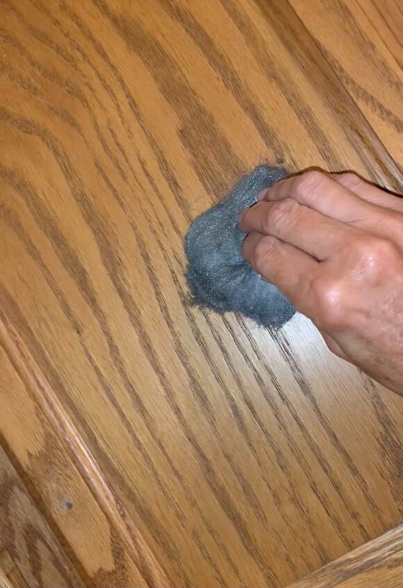 a person is cleaning the wooden floor with a rag