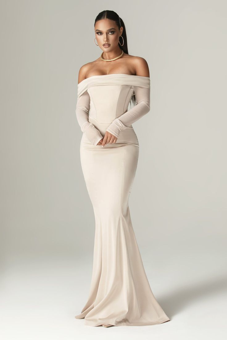 This spectacular maxi dress is a real show-stopping piece, designed with the romance and glamour of old Hollywood. 'Giulia' is expertly crafted from our ultra-luxe duchess satin and features our signature corsetry to give the perfect figure cinching and ultimate lift. The internal layer is lined in textured fabric to ensure a non-slip effect. The draped satin extends across the bust in a flattering Bardot neckline and around the arm tops, falling to long, slim-fitting mesh sleeves. The delicate Long Neutral Dress, Hollywood Red Carpet Dresses, Old Hollywood Glamour Fashion, Old Hollywood Glamour Dresses, Hollywood Glamour Dress, Mermaid Corset, Straight Wedding Dresses, Neutral Dress, Hollywood Red Carpet