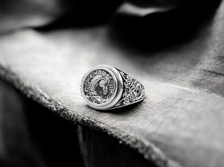 a man's ring sitting on top of a piece of cloth