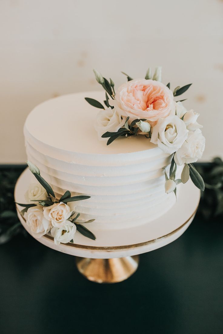 a white wedding cake with flowers on top