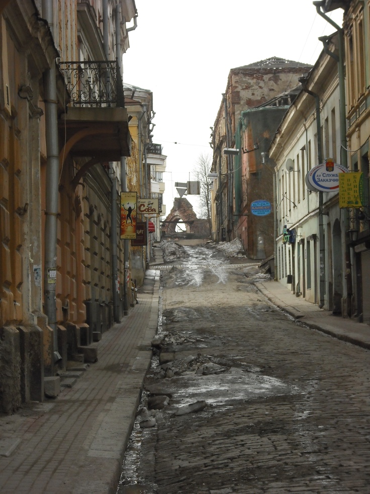 an old city street with no cars on it and buildings lining both sides, in the middle of town