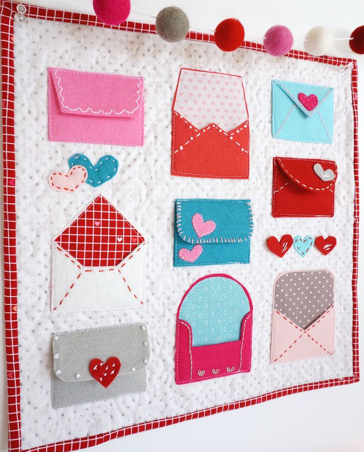 a close up of a wall hanging with different types of envelopes and hearts on it