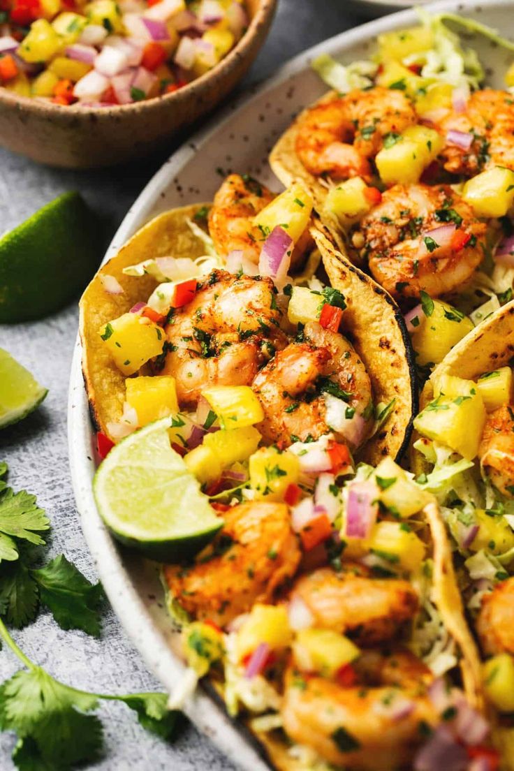 shrimp tacos with pineapple salsa and cilantro garnish on a plate