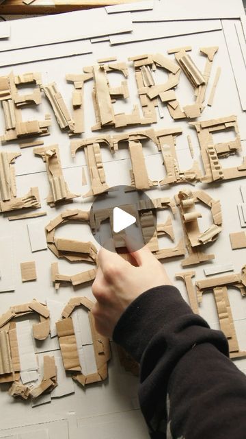 a person is working on some type of art work with wooden letters and numbers in the background