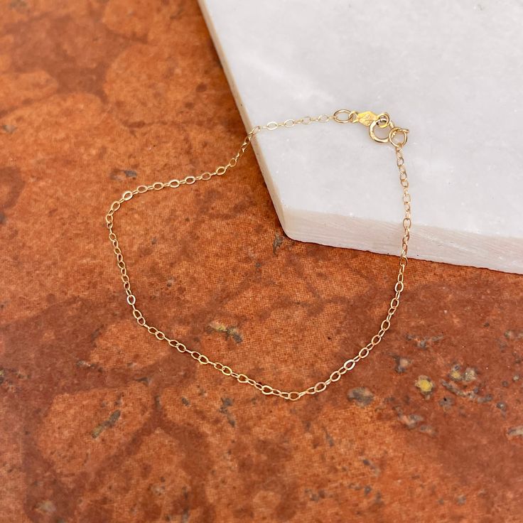 14KT yellow gold flat cable link chain bracelet. A delicate and minimal chain bracelet to wear sold or layering with more bracelet. 7" in Length 1.30mm in width 14KT Gold Spring Lock Clasp Weight: .34 gram Stamped 14K Dainty Bracelet With Cable Chain And Oval Link, Dainty Cable Chain Bracelet With Oval Links, Dainty Link Chain Bracelet With Delicate Chain, Gift Yellow Gold Chain Bracelet With Cable Chain, Yellow Gold Cable Chain Bracelet As Gift, Gift Yellow Gold Cable Chain Bracelet, Dainty Gold Bracelet With Cable Chain Links, Minimalist 14k Gold Chain Bracelet With Extender, Minimalist Yellow Gold Bracelet With Rolo Chain